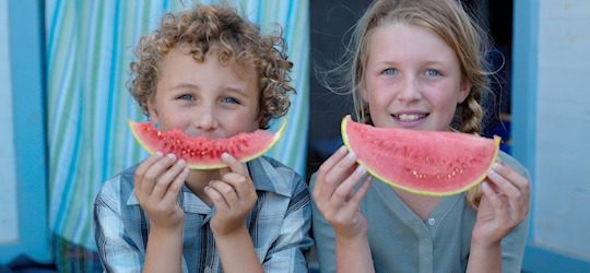 Niños comiendo sandía