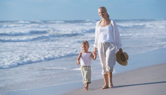 Madre soltera paseando con su hijo por la playa