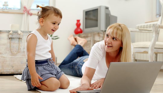 Madre jugando con su hijo en el ordenador