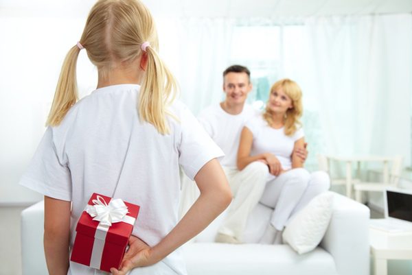 Niña antes de darle el regalo a su padre