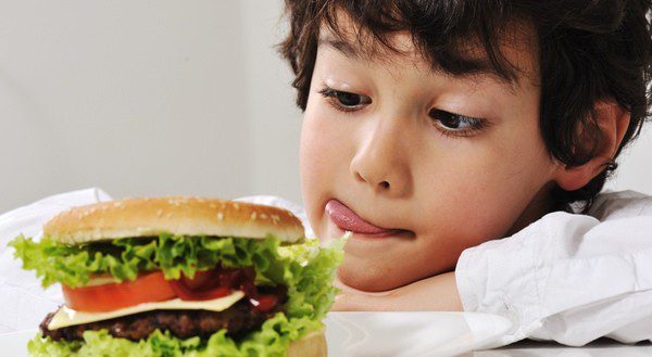 Niños merendando una hamburguesa