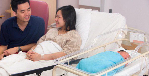 Pareja junto a su hijo recién nacido en la habitación del hospital