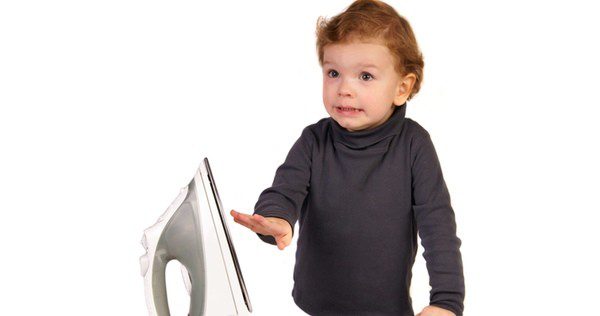 Niño a punto de quemarse con una plancha caliente