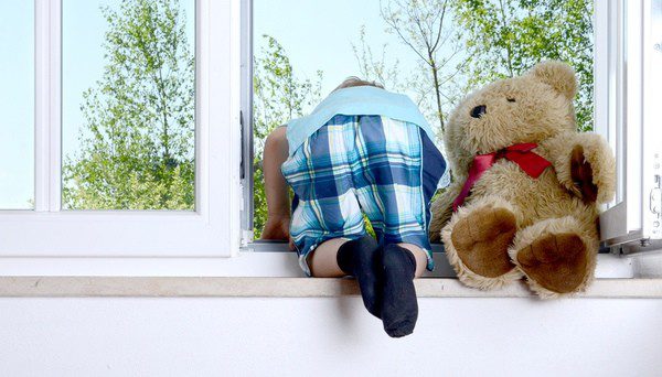 Niño asomándose de forma muy peligrosa por la ventana