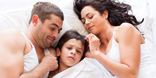 Menor con sus padres en la cama