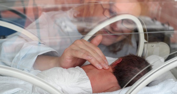 Madre mirando a su hijo en la incubadora