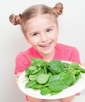 Niña con un plato de espinacas