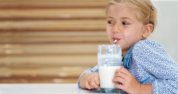 Niña bebiendo un vaso de leche