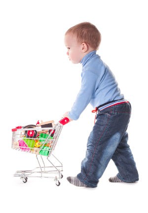 Niño con un carrito de la compra de juguete
