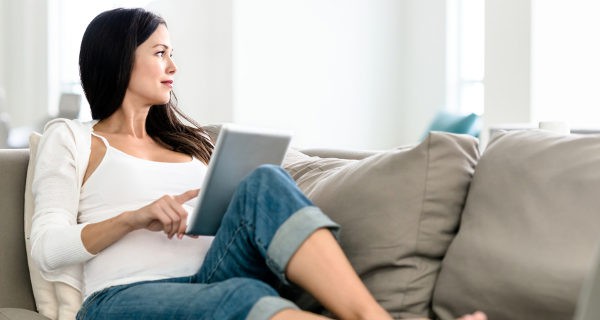 Mujer descansando en el sofá con una tablet