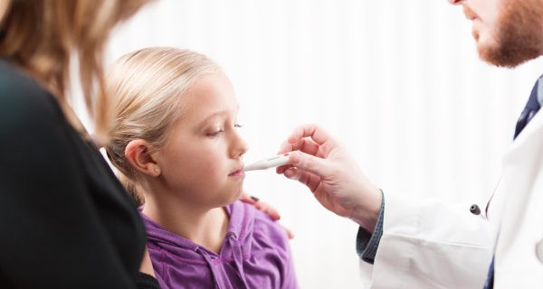 Médico tomando la fiebre a una niña