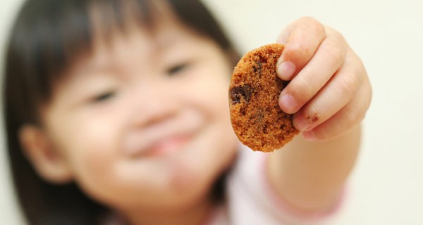 Niña ofrecienda su galleta