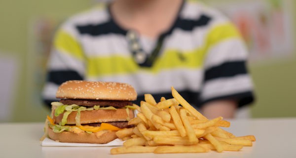 Niño comiendo hamburguesa y patatas