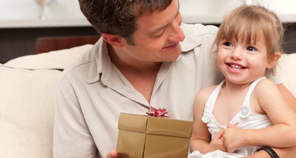 Padre haciéndole un regalo a la hija
