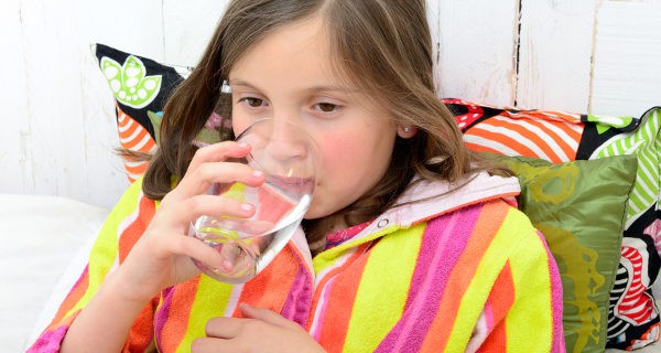 Niña enferma bebiendo agua