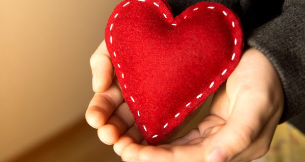 Niño regalando un corazón