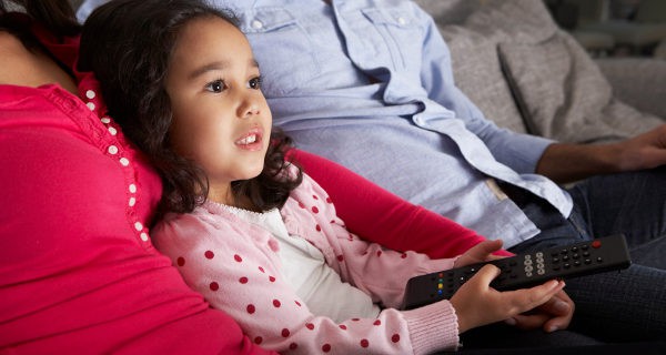 Niña viendo la tele con sus padres