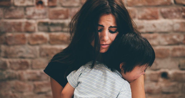 niño llorando abrazado a su madre