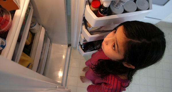 niña buscando comida en la nevera