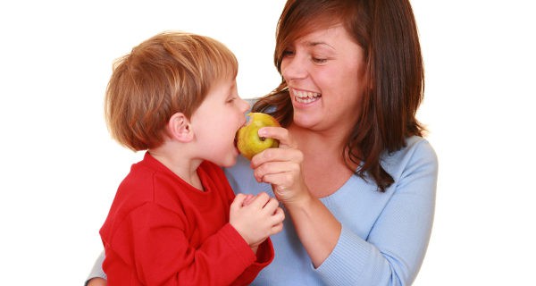 mujer dando fruta su hijo
