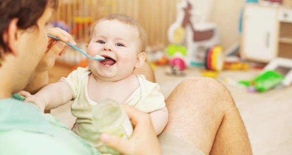 padre dando de comer a su bebé