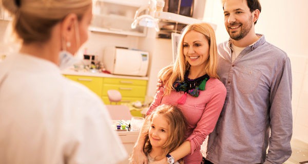 padres e hija en el dentista