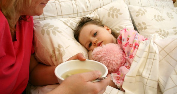 madre dando sopa a niña enferma
