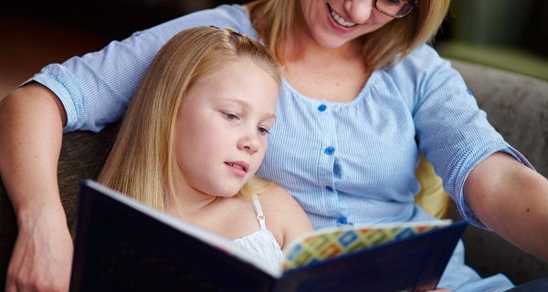 niña leyendo un cuento con su madre