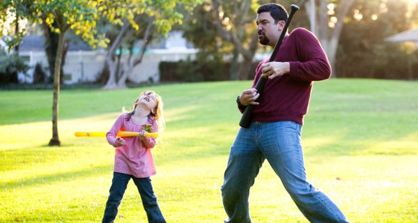 padre e hija bailando en un parque