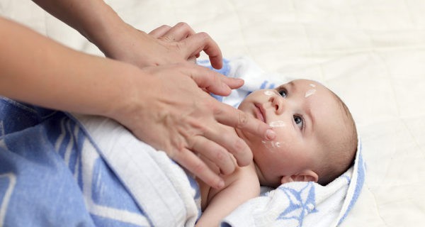 echando crema al bebé