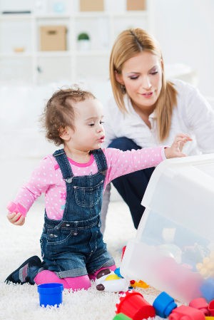 niña recogiendo los juguetes