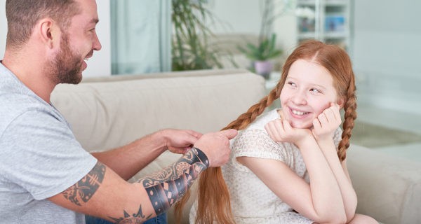 padre haciendo trenzas a su hija