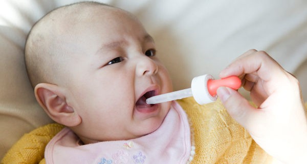 dando medicamento por pipeta a un bebe