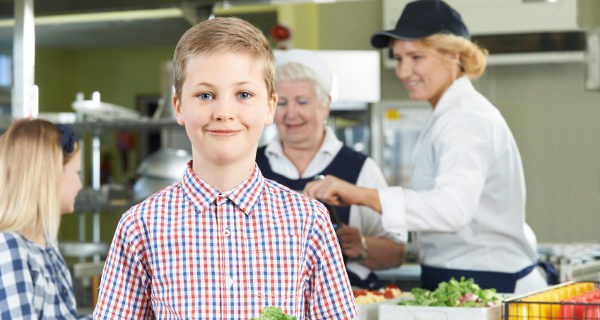 niño en el comedor del colegio