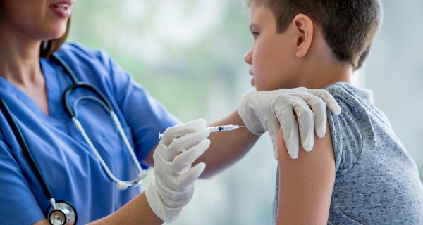 médico poniendo una vacuna a un niños